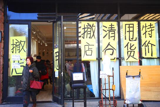 "撤店,清仓,甩货,特价"的醒目标语贴满店铺玻璃,吸引顾客.